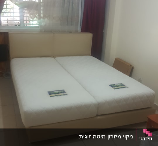 מיטה זוגית עם מזרנים לבנים בחדר שינה